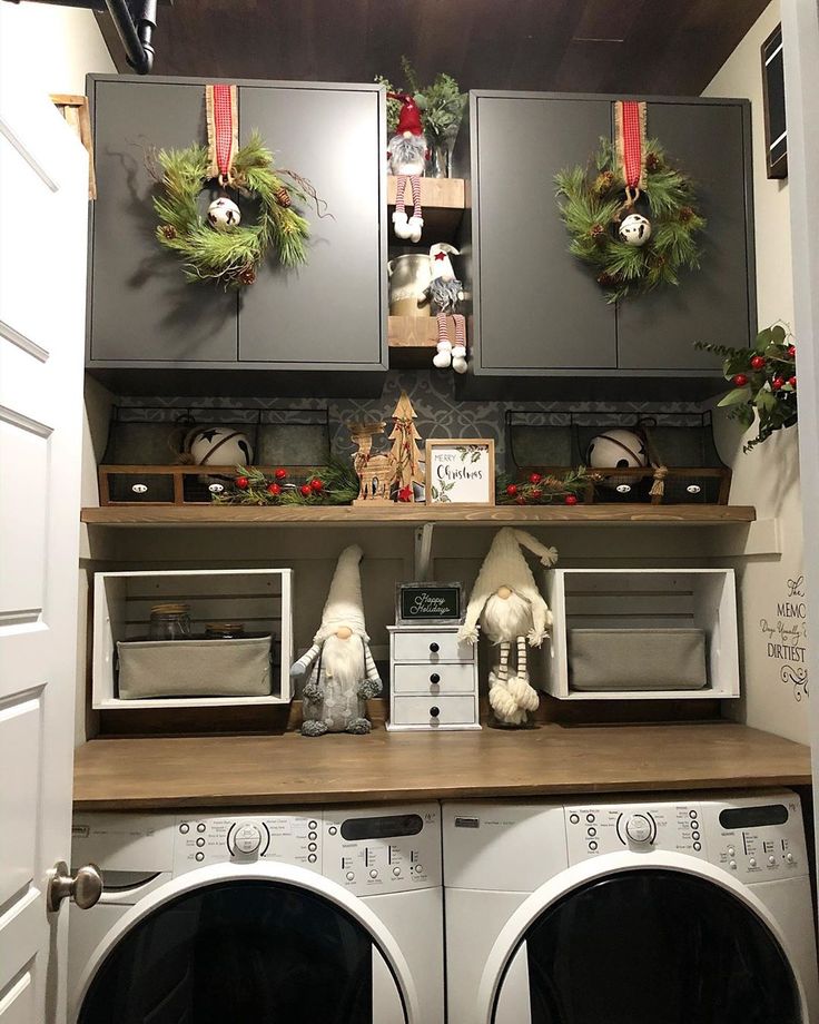 a washer and dryer in a room with christmas wreaths on the cabinets