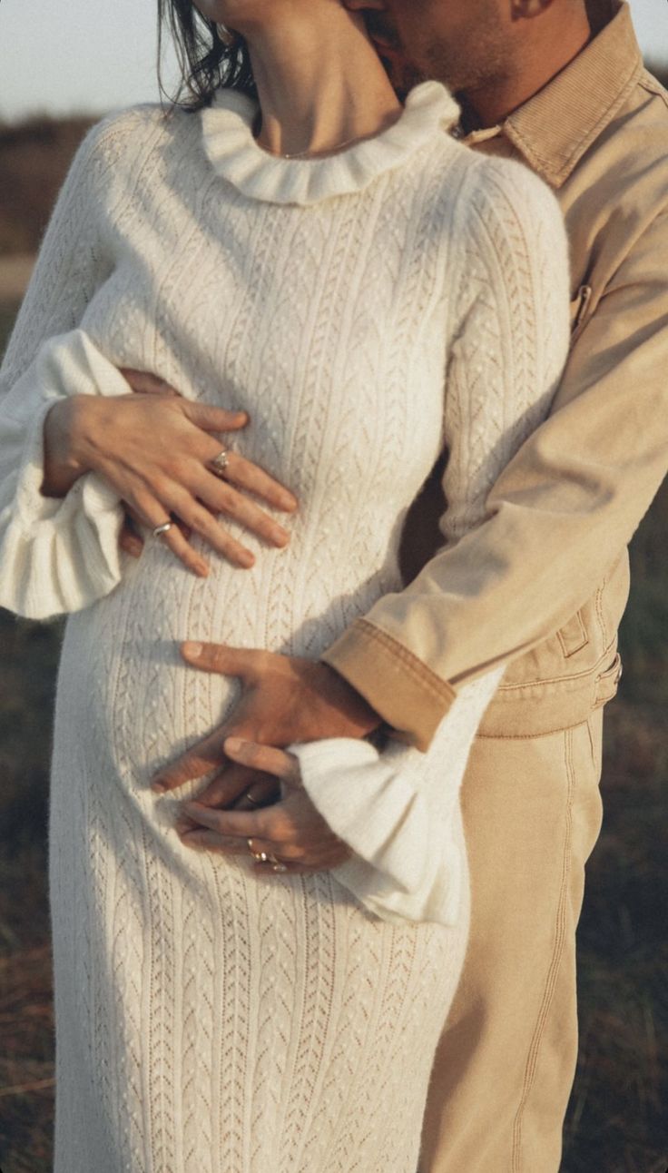 a man and woman embracing each other in the grass