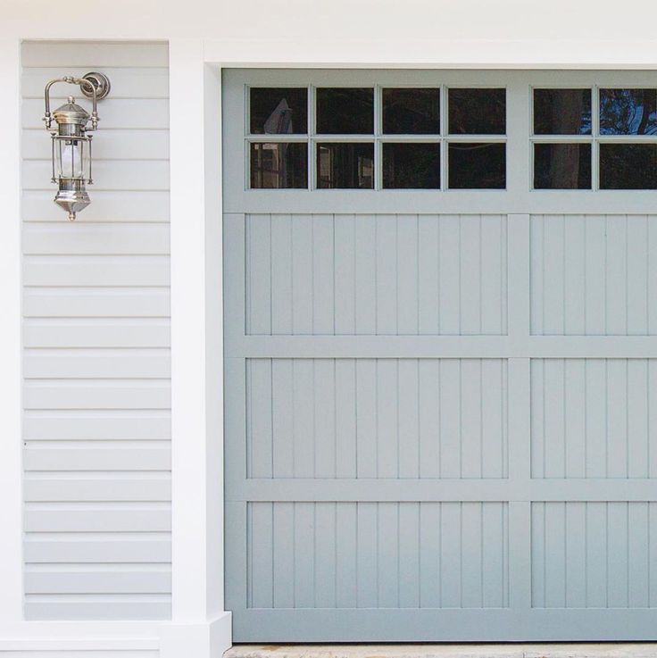 a white house with a gray garage door