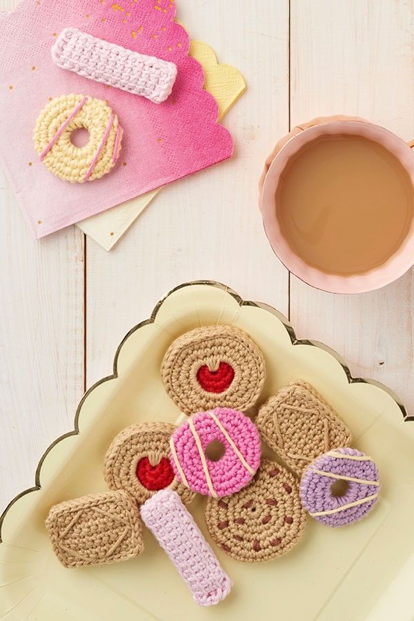 crocheted cookies on a plate next to a cup of coffee