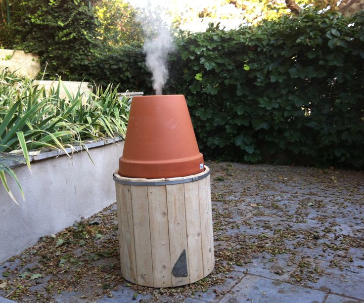 a large brown pot sitting on top of a cement floor next to a planter