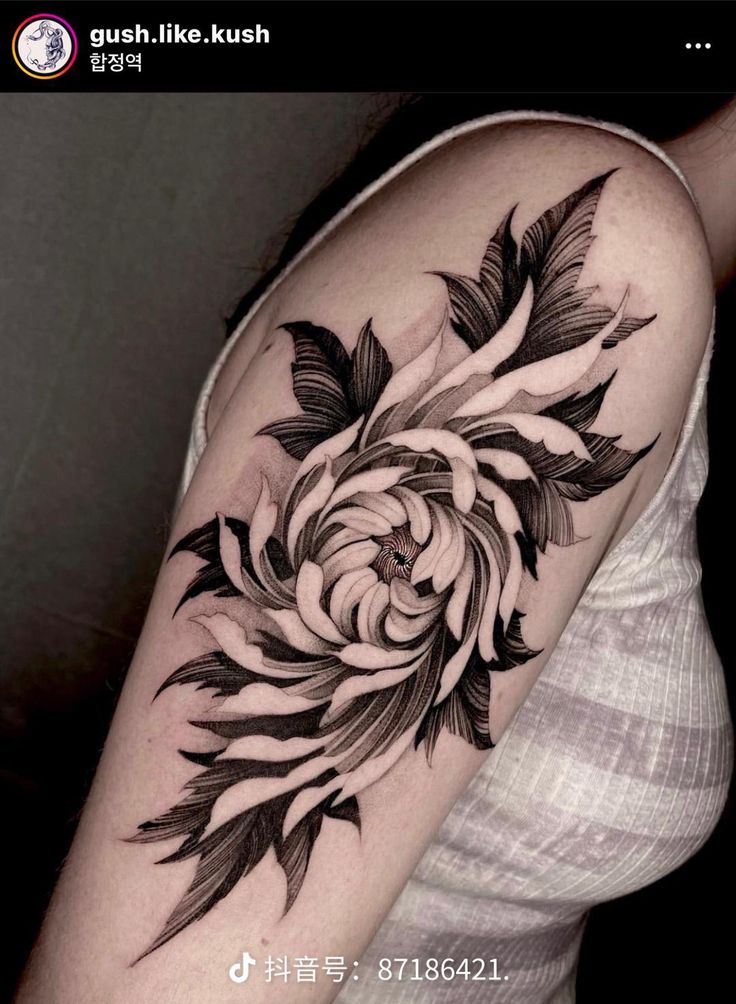 a black and white flower tattoo on the arm