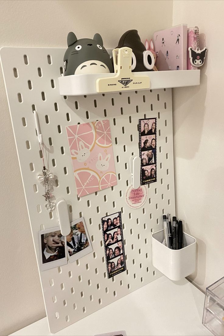 a white shelf with pictures and magnets on it, next to a cup holder