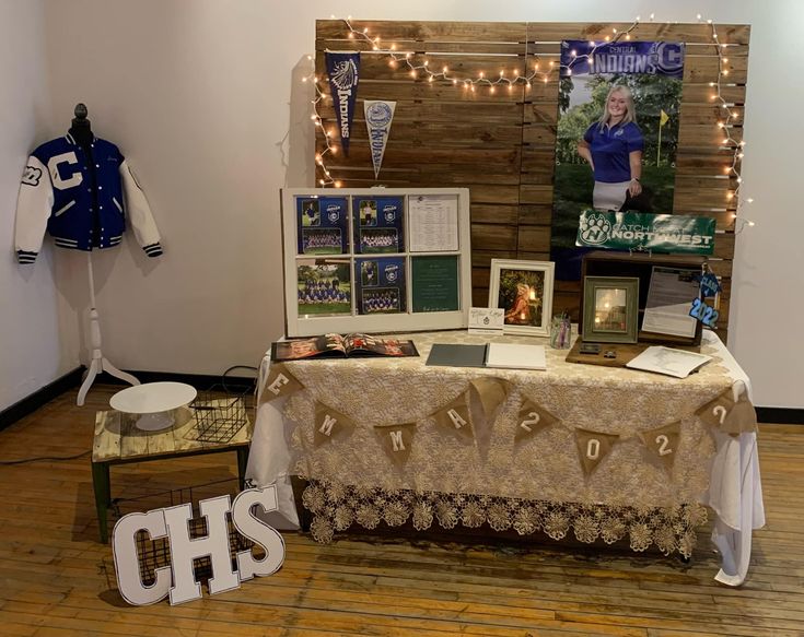 a table with pictures and other items on it in front of a wall that has lights