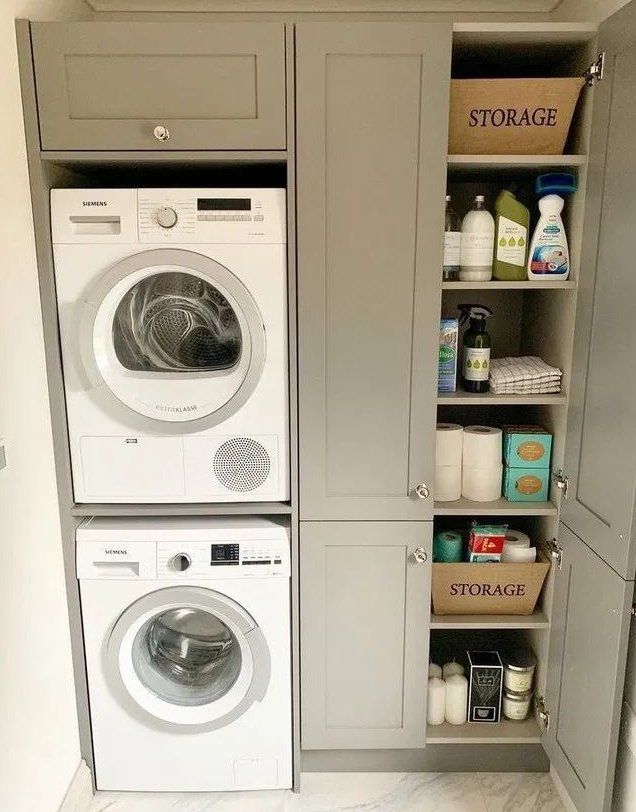 a washer and dryer in a small room next to some shelves with bottles