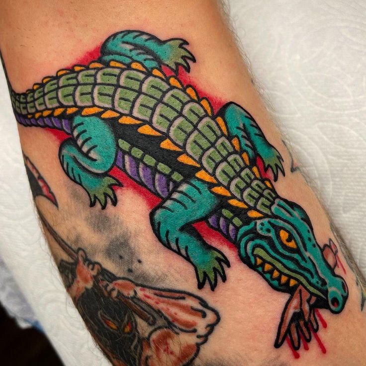 an arm with a lizard tattoo on it