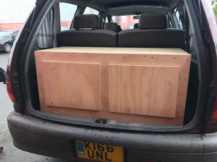 the back end of a car with two wooden boxes in it's trunk area