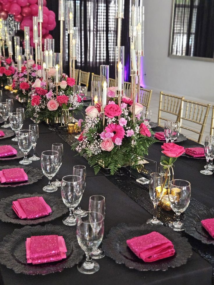 a long table is set with pink napkins and place settings for an elegant dinner