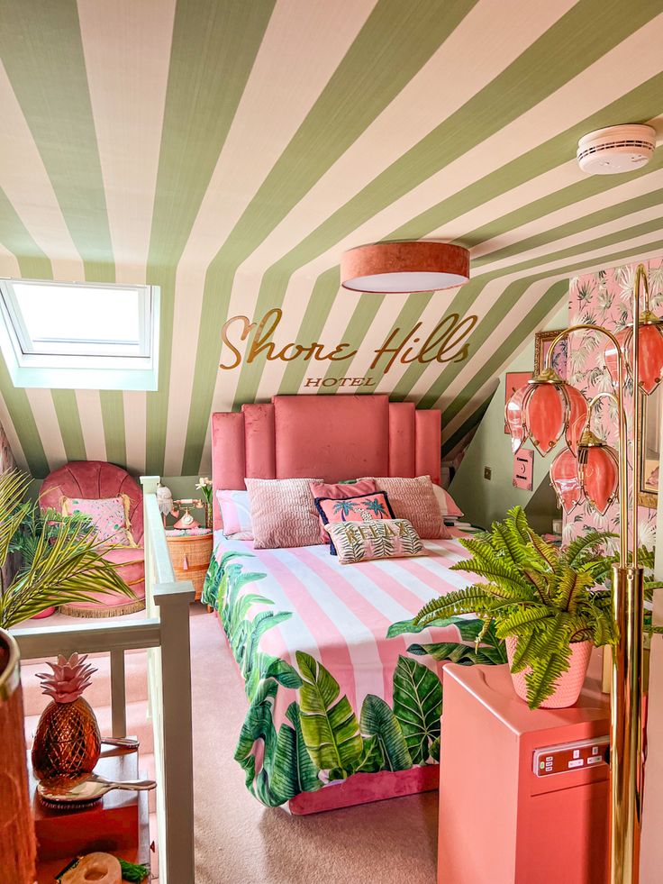 a bedroom decorated in pink, green and white stripes