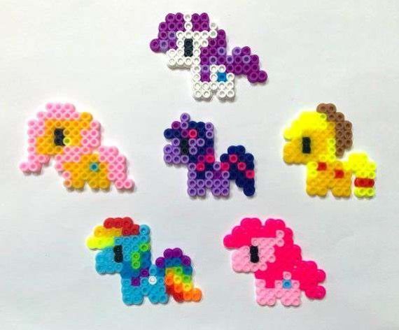 six different types of pony beads on a white surface with one being made out of legos