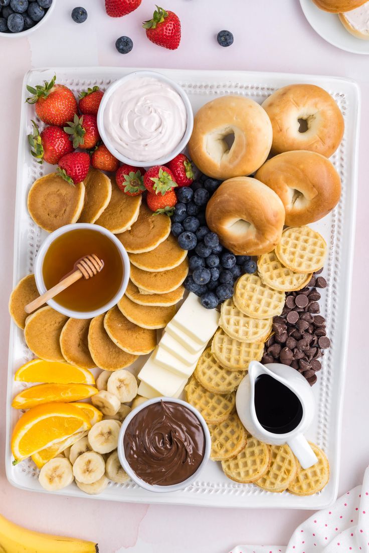 a platter filled with fruit, waffles and other snacks