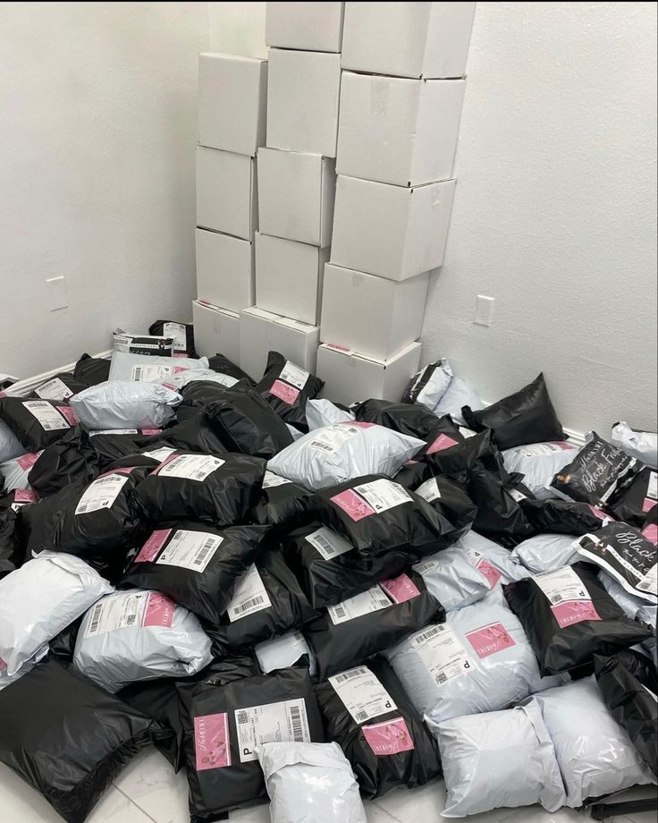 a pile of black and white bags sitting on top of a floor next to boxes