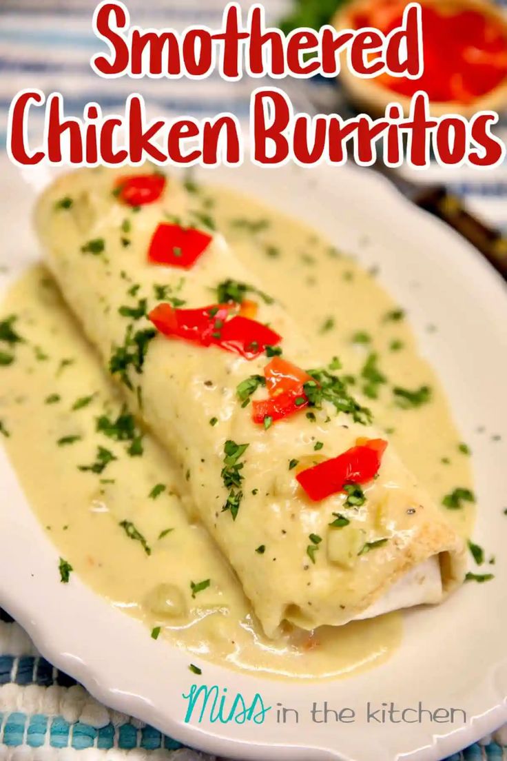 a white plate topped with two enchiladas covered in sauce and garnished with red peppers