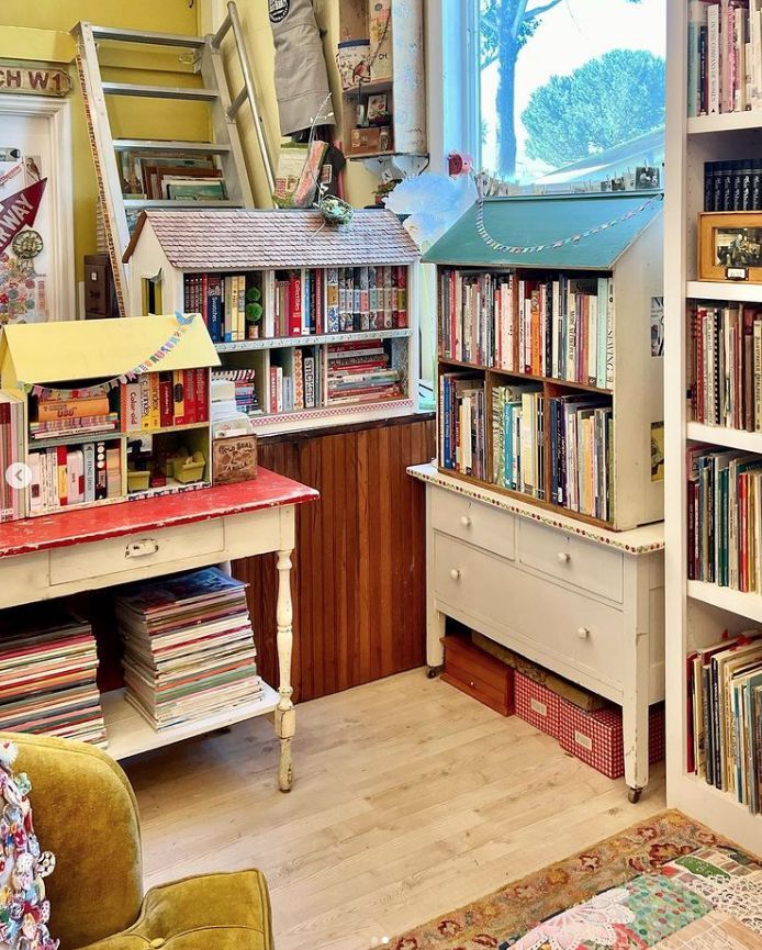 a room filled with lots of books and furniture