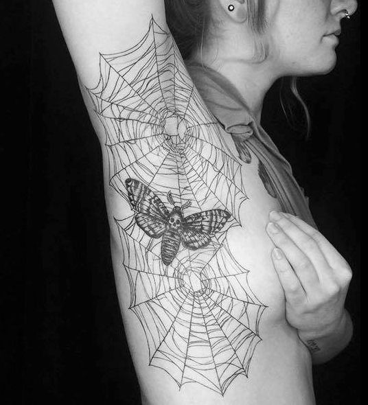 a woman with a spider web tattoo on her arm