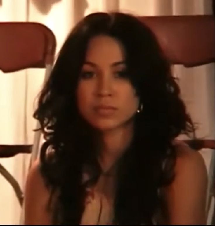 a woman with long hair sitting in a chair