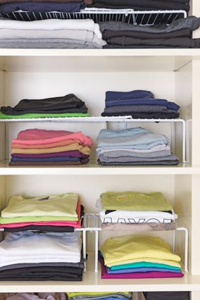 an organized closet with folded clothes and folded t - shirts on shelving unit shelves