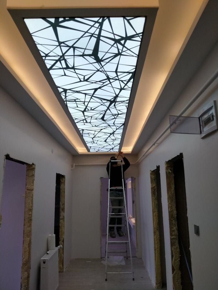 a man standing on a ladder working on the ceiling