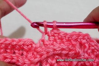 someone crocheting the stitchs together with pink yarn