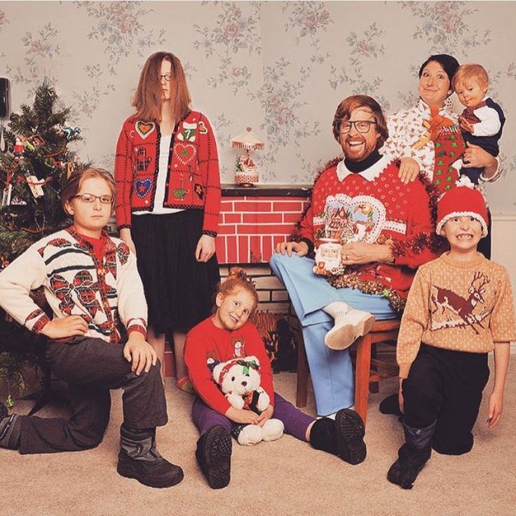 a group of people in ugly sweaters posing for a photo