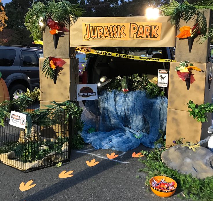 the entrance to a park with fake trees and plants on display in front of it