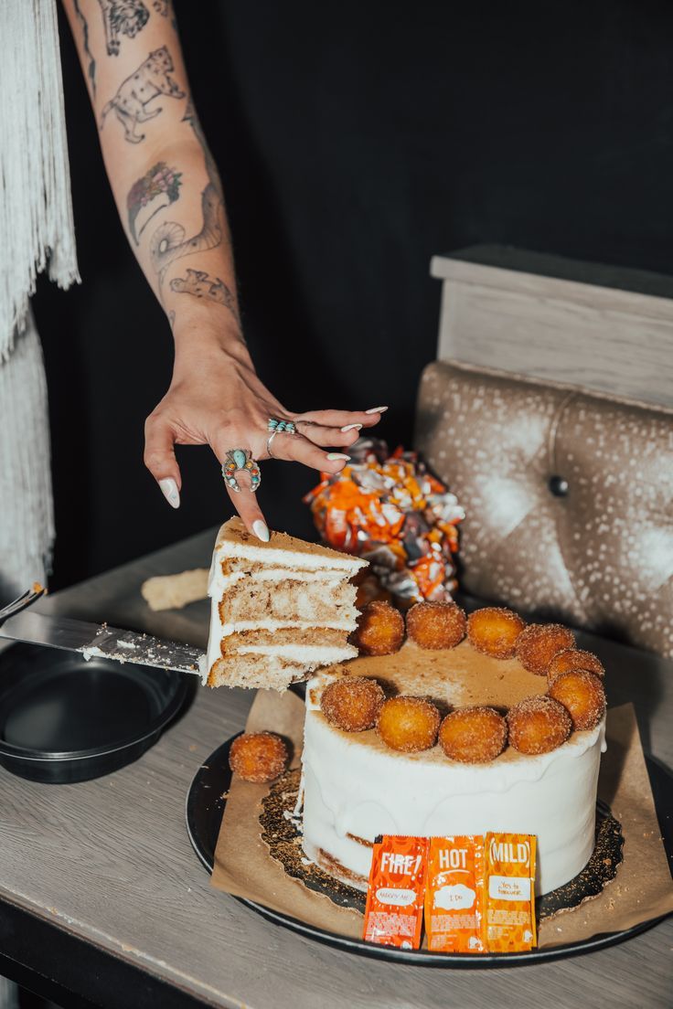 a woman is cutting into a cake with oranges on the table next to it