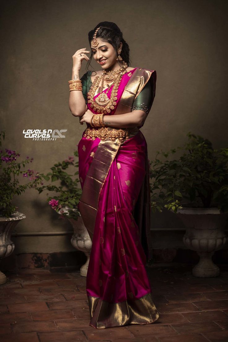 a woman in a pink and gold sari