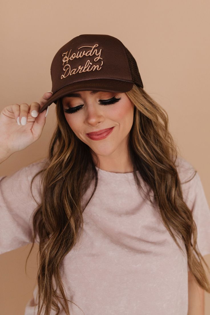 Say hello to the perfect summer accessory with our Howdy Darlin' Trucker Hat! Made with a classic trucker design, this brown hat features "Howdy Darlin'" embroidered on the front. Keep cool and stylish all summer long with this trendy hat! Paired with THE MACIE DRAWSTRING BARREL JEANS IN LIGHT BLUE STRIPE Howdy Darlin' embroidered on front in tan Trucker style Adjustable snapback 100% polyester Due to sanitary reasons, accessories are FINAL SALE. Check out our try on video below! Country Style Adjustable Brown Trucker Hat, Western Style Brown Trucker Hat, Brown Trucker Hat For Country Events, Brown Country-style Trucker Hat With Short Brim, Brown Trucker Hat For Western-themed Events, Trucker Hat Women, Happy Threads, Summer Goddess, Barrel Jeans