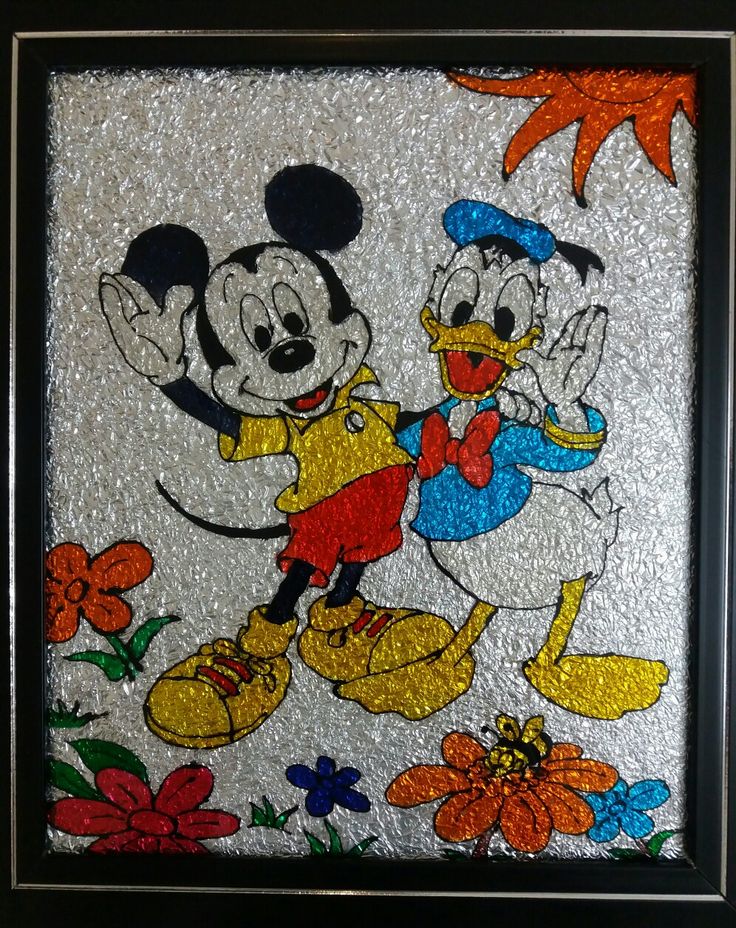 the mickey and minnie mouse stained glass artwork is displayed in a black frame with flowers on it