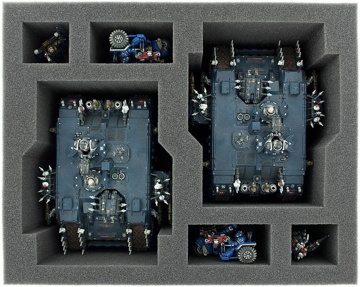 an overhead view of the inside of a plastic box with multiple parts in it, including two engines and four wheels