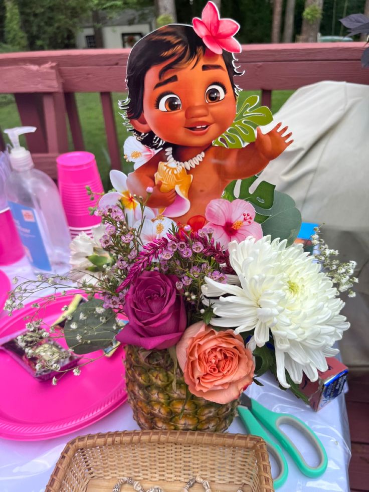 a table topped with flowers and other items on top of a wooden bench next to a basket