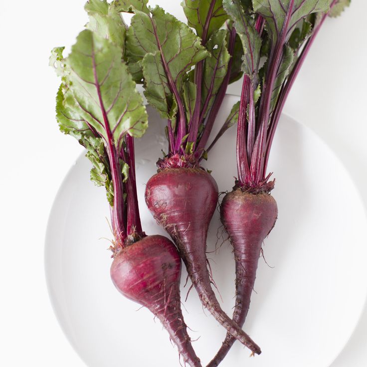 three purple turnips on a white plate