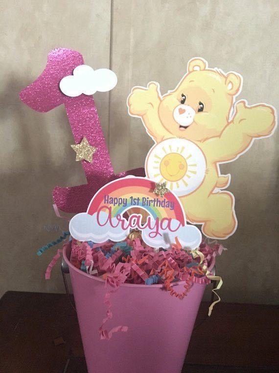 a pink bucket filled with lots of confetti next to a happy 1st birthday sign