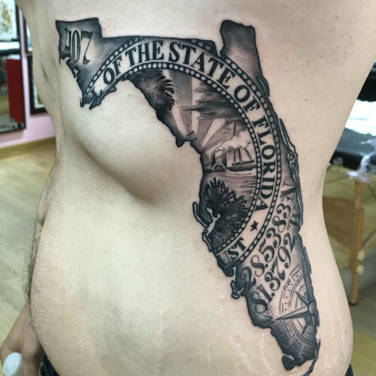 a woman's stomach with the state of florida tattoo on her side, in black and white