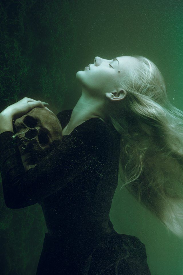 a woman with long hair standing under water