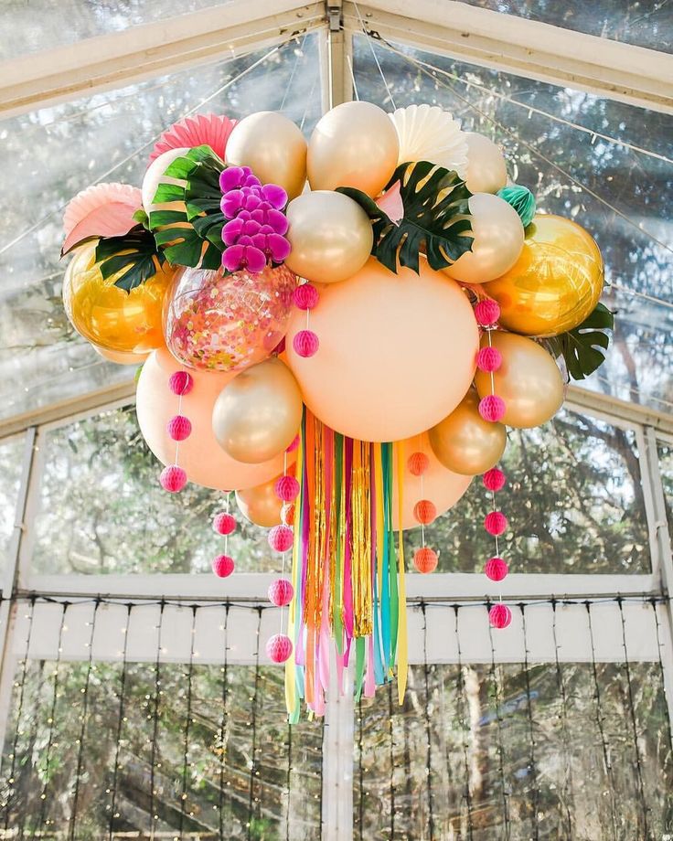 a bunch of balloons that are hanging from a ceiling