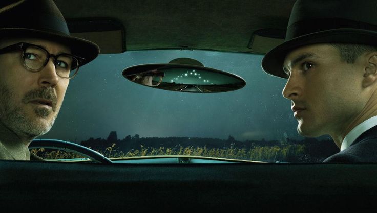 two men in hats are sitting in the back seat of a car looking at each other