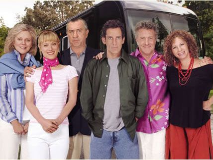 a group of people standing next to each other in front of a bus and trees