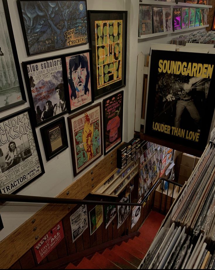 there are many records on the wall next to each other in this room with posters all over it