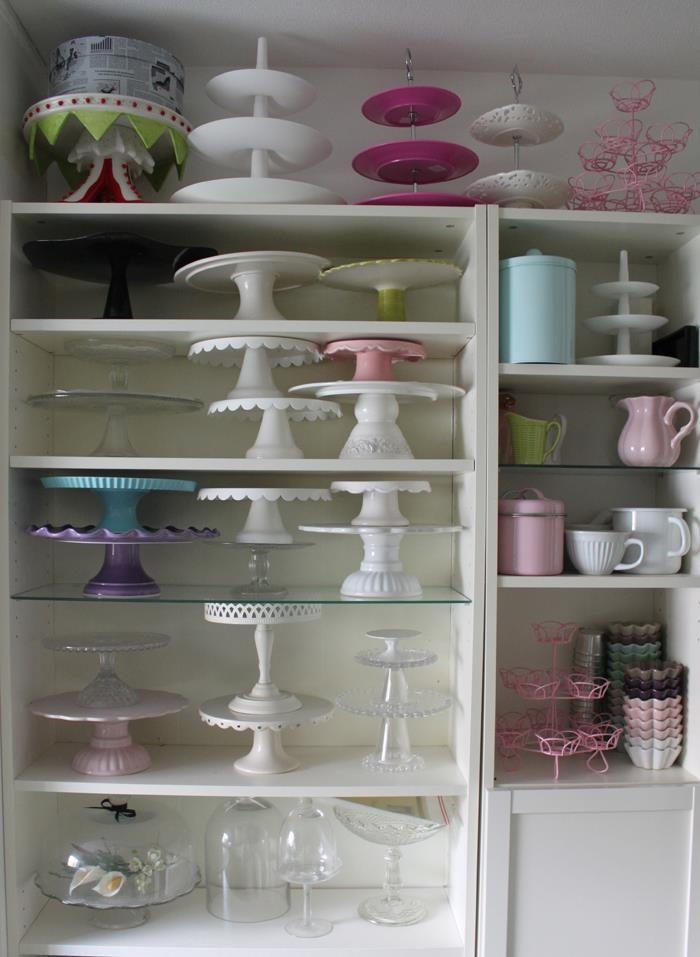 the shelves are filled with many different types of dishes and vases, all in white