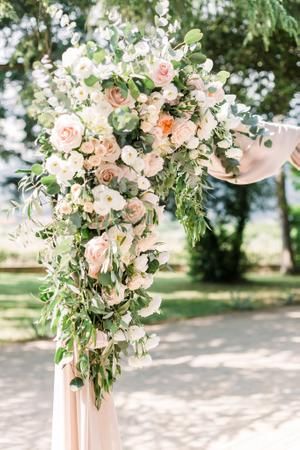 a wedding arch decorated with flowers and greenery