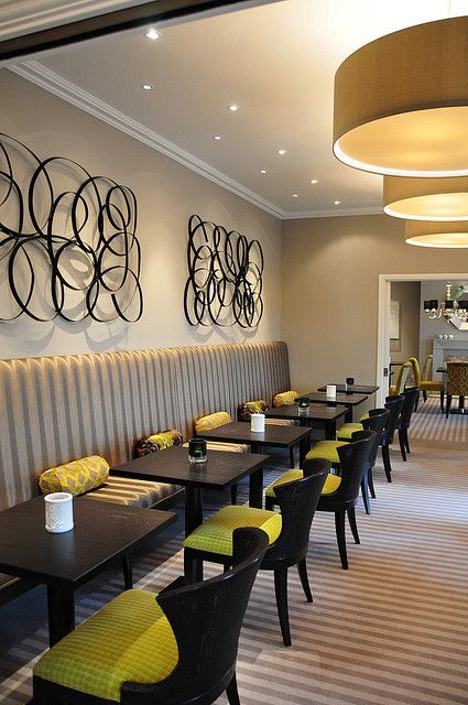 a restaurant with yellow and black chairs and striped carpeted flooring on the walls