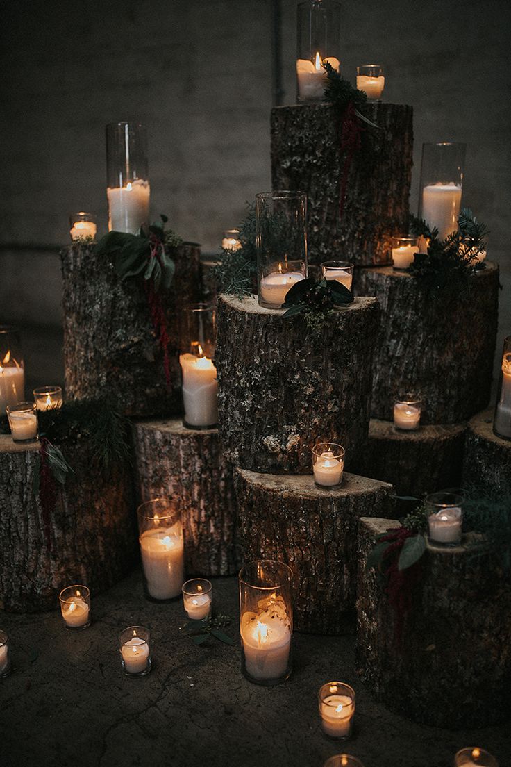 many lit candles are placed on wood logs