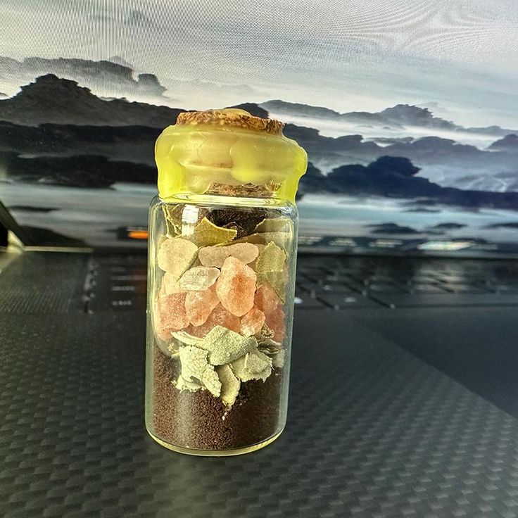 a jar filled with lots of different types of candies on top of a table