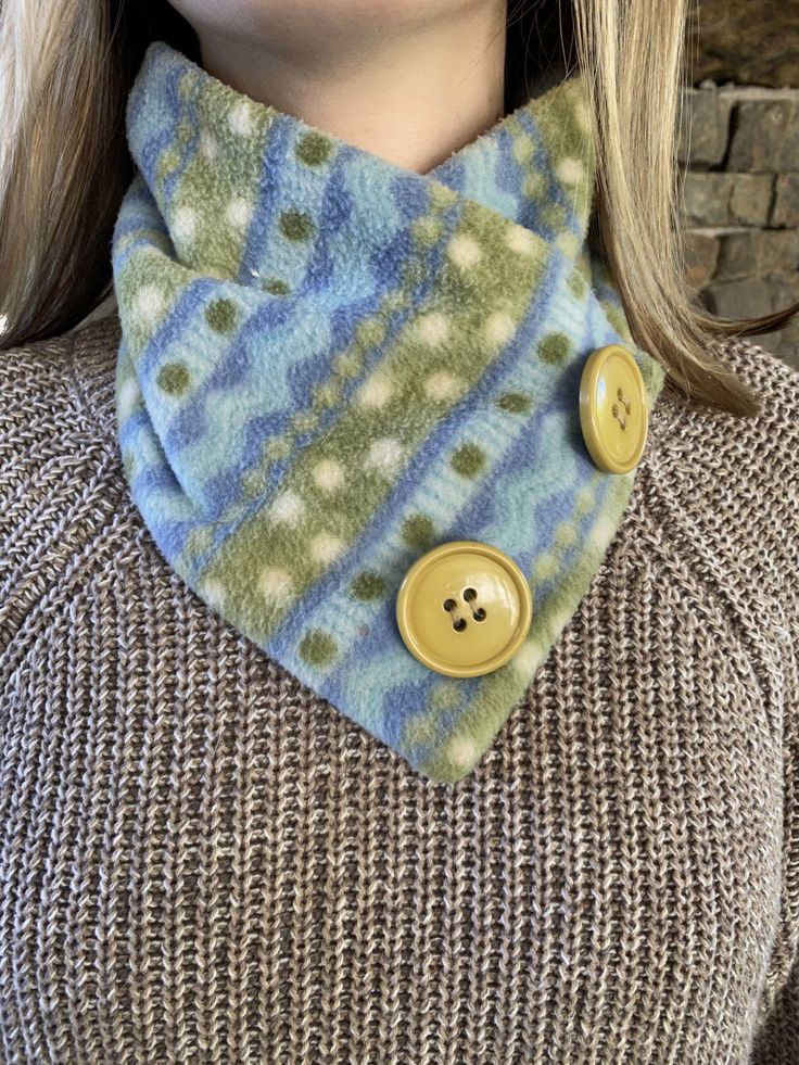 a woman wearing a scarf with buttons on it