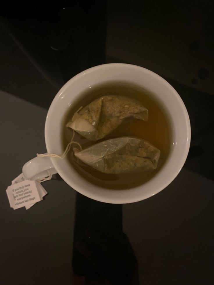 a white bowl filled with soup on top of a black table next to a tag