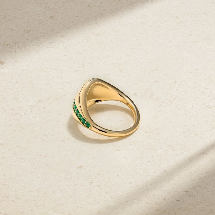 A fun ring that's both sleek and contemporary and infused with heirloom quality, our Saturn Ring is surprisingly lightweight and features a slightly domed top that's inlaid with a row of beautiful emeralds. The metal has been polished with a high luster and lays flush against the finger making it an ideal choice for every day. Wear yours alone alongside other daintier rings. Metal: 18kt Gold Emerald Weight: 0.35 ct. Measurements: 13.0 mm length *Please note that the listed ct. weights are approx Luxury Emerald Ring With Tension Setting, Timeless Polished Emerald Ring, Modern Diamond Ring For May Birthstone, Modern Green Diamond Promise Ring, Modern May Birthstone Diamond Ring, Modern Green Signet Ring With Polished Finish, Green Dome Ring With Polished Finish For Anniversary, Modern Yellow Gold Emerald Ring For May Birthstone, Modern Gold Rings With Emerald