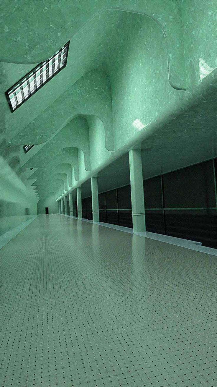 an empty subway station with green walls and tiled floor