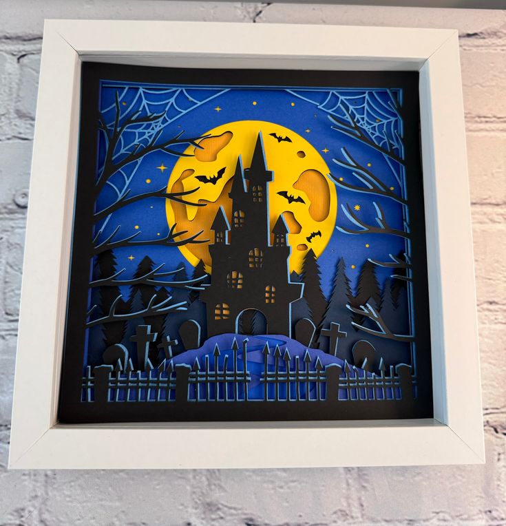 a paper cut image of a castle in the night with bats and full moon behind it