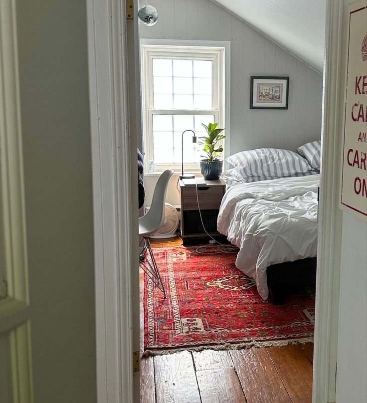 an attic bedroom with a bed and rug